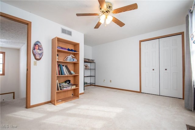 carpeted bedroom with ceiling fan and a closet