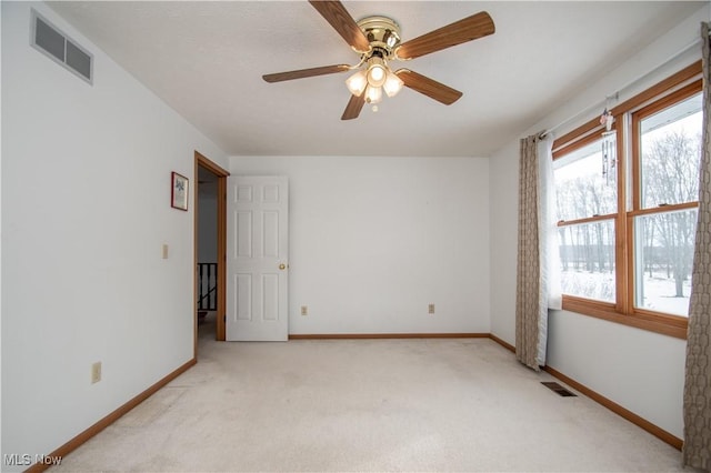 empty room featuring plenty of natural light, light colored carpet, and ceiling fan