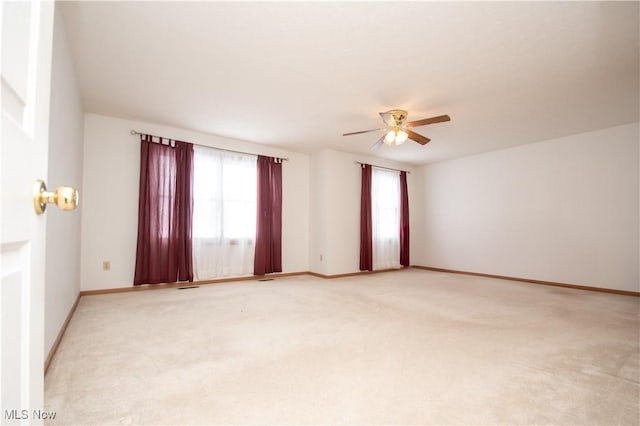 carpeted spare room featuring ceiling fan