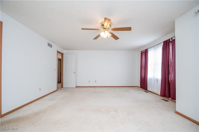 carpeted spare room featuring ceiling fan