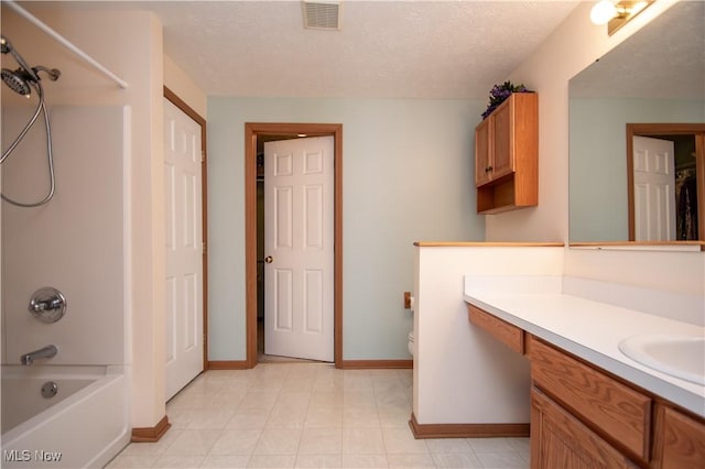 full bathroom featuring shower / tub combination, vanity, toilet, and a textured ceiling