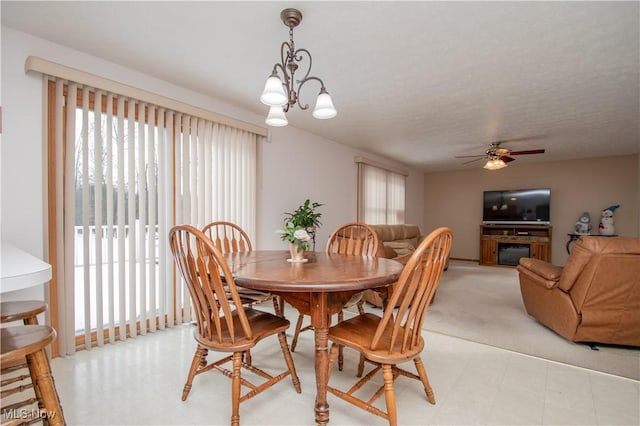 dining space with plenty of natural light and ceiling fan with notable chandelier