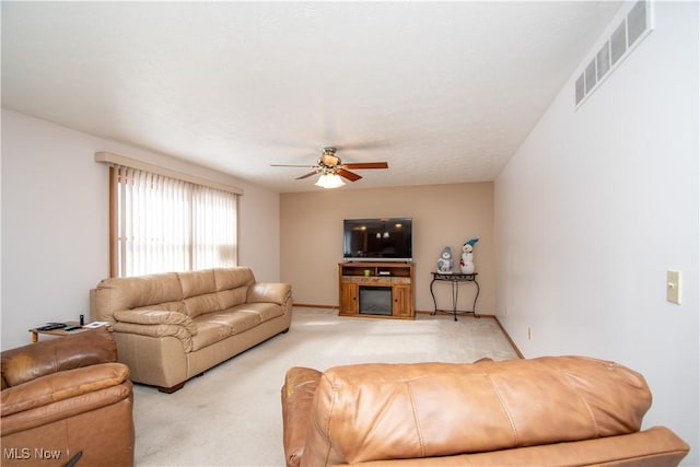 carpeted living room with ceiling fan