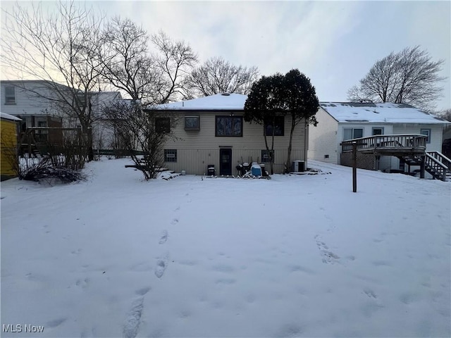 snow covered back of property featuring a deck and central air condition unit