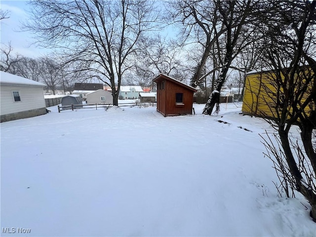 yard covered in snow with a storage unit