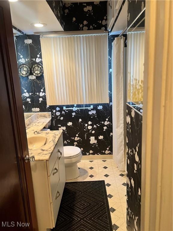 bathroom featuring tile patterned floors, toilet, and vanity