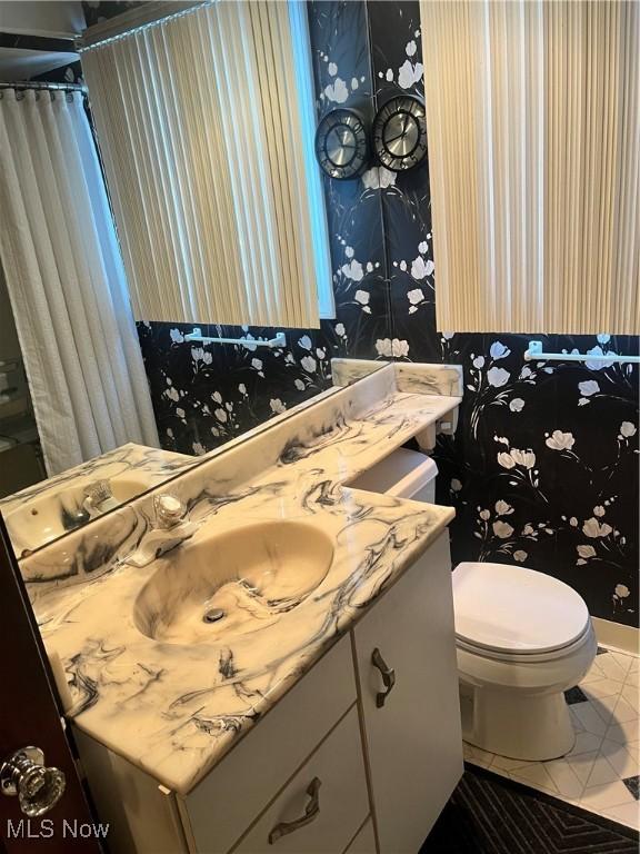 bathroom featuring toilet, vanity, and tile patterned flooring