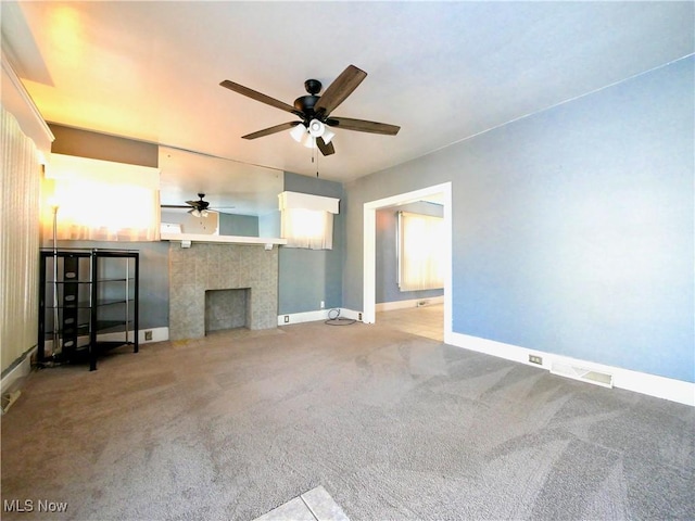 unfurnished living room with light colored carpet, a fireplace, and ceiling fan