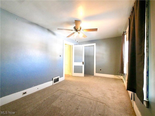 carpeted spare room featuring ceiling fan