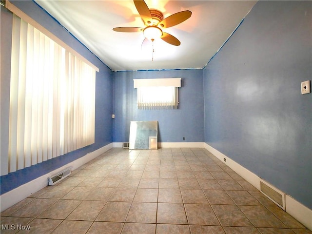 tiled empty room featuring ceiling fan