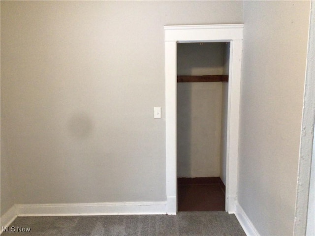 hall featuring dark colored carpet