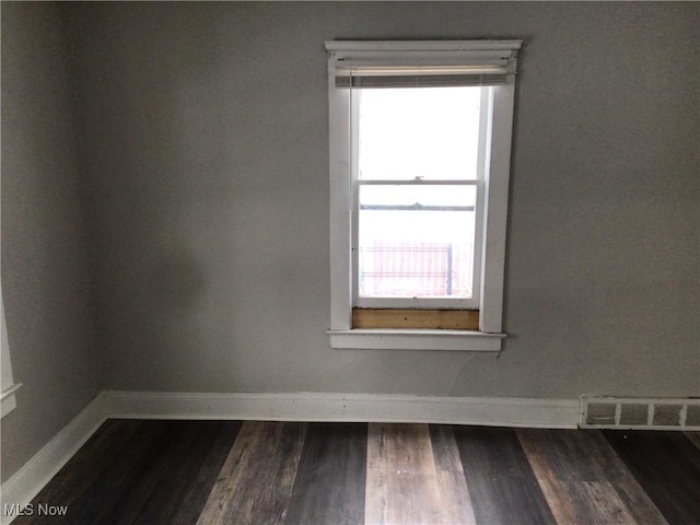 empty room featuring dark hardwood / wood-style floors and a healthy amount of sunlight