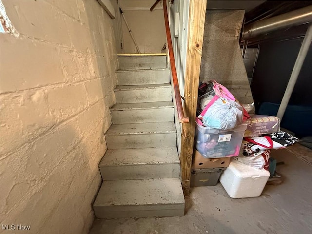 stairs featuring concrete flooring