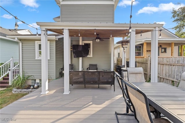 wooden deck with ceiling fan and outdoor lounge area