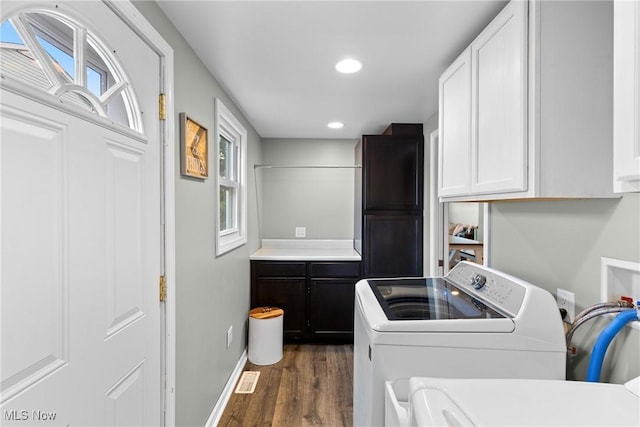 laundry room featuring cabinets, dark hardwood / wood-style floors, and independent washer and dryer