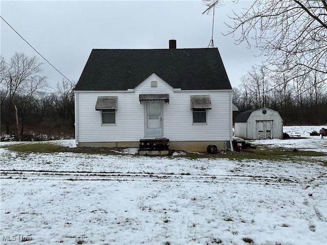 snow covered house with a storage shed