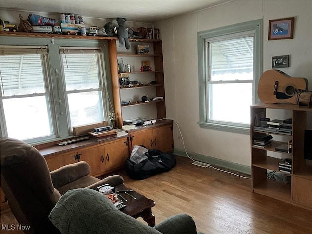 living area with a wealth of natural light and light hardwood / wood-style flooring