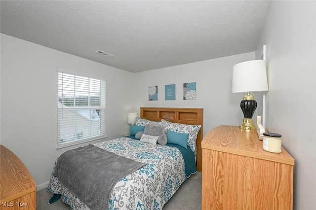 bedroom featuring carpet and a textured ceiling