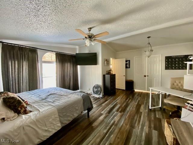 bedroom with a textured ceiling, dark hardwood / wood-style floors, vaulted ceiling, ceiling fan, and crown molding