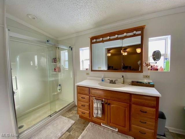 bathroom featuring vanity, a textured ceiling, lofted ceiling, and walk in shower