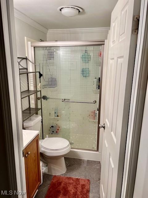 bathroom featuring toilet, vanity, tile patterned floors, crown molding, and an enclosed shower