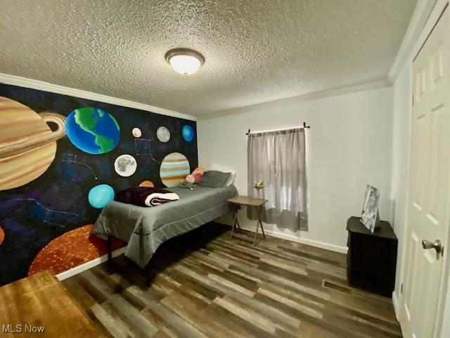 bedroom featuring a textured ceiling, crown molding, and hardwood / wood-style flooring