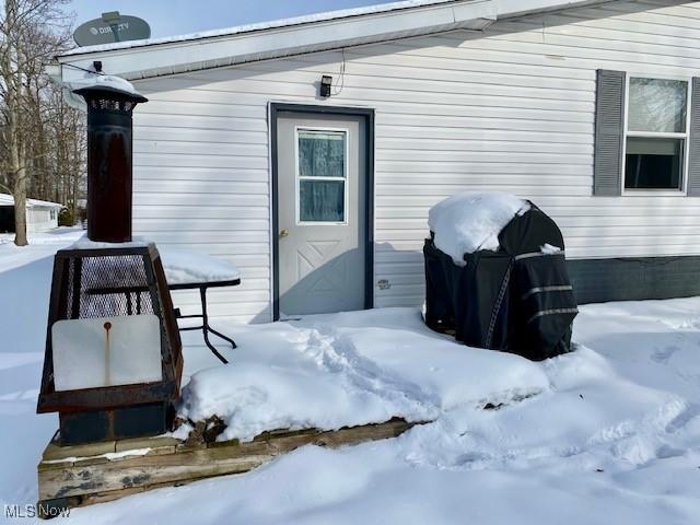 snow covered patio with a grill