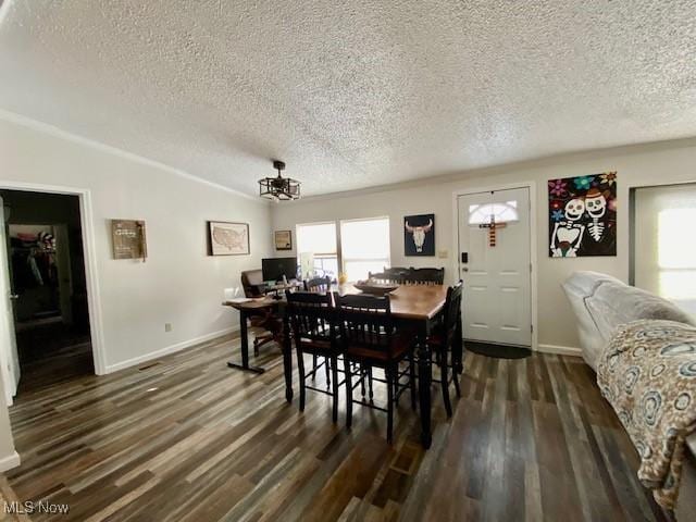 dining space with a textured ceiling, dark hardwood / wood-style flooring, lofted ceiling, and a chandelier