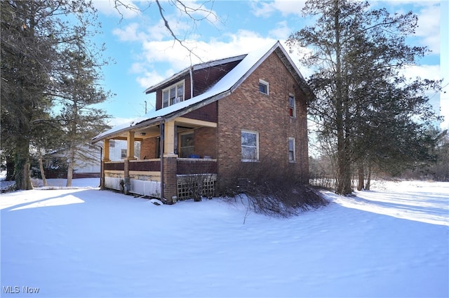 snow covered property featuring a porch