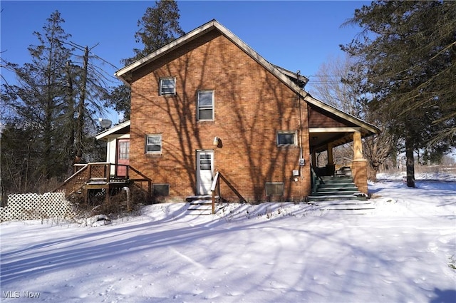 view of snow covered back of property