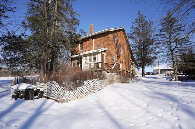 view of snow covered back of property