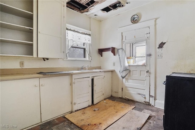 kitchen featuring sink, white cabinets, and stove