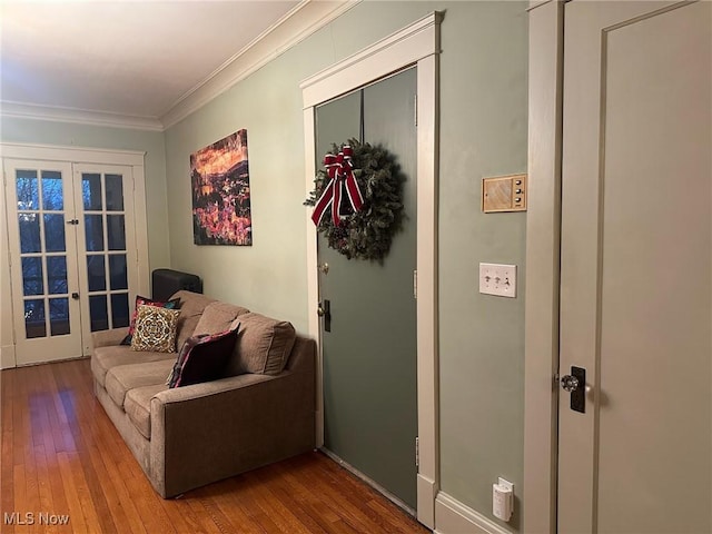 living area with hardwood / wood-style flooring, crown molding, and french doors