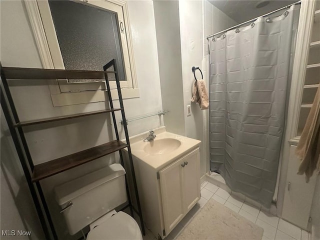 bathroom with curtained shower, tile patterned floors, vanity, and toilet