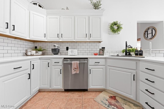 kitchen featuring white cabinetry, stainless steel dishwasher, sink, and light tile patterned floors