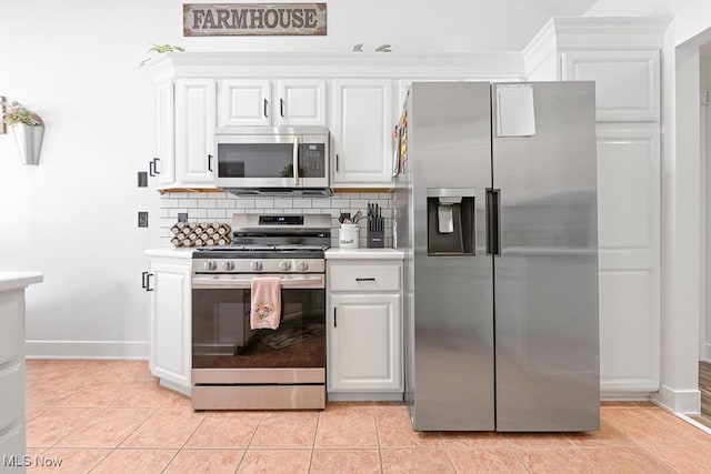 kitchen featuring light tile patterned flooring, white cabinetry, stainless steel appliances, and decorative backsplash