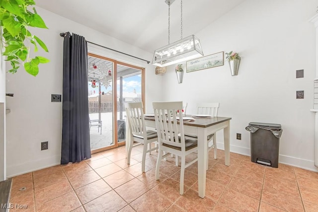 dining room featuring lofted ceiling and light tile patterned flooring