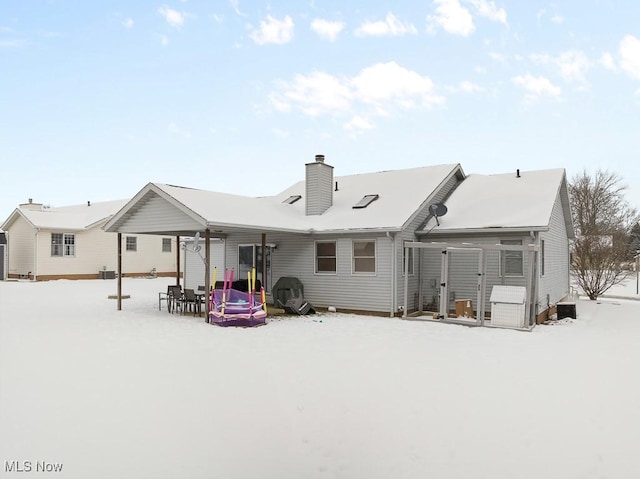 view of snow covered back of property