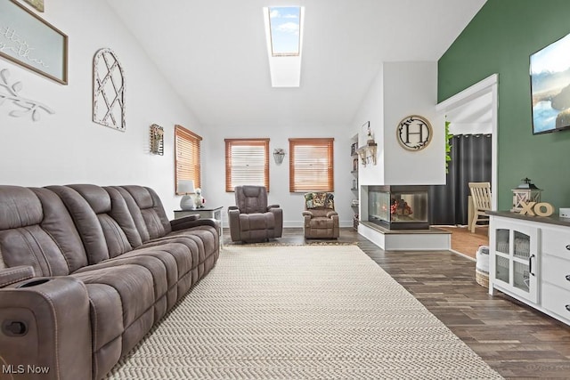 living room with dark wood-type flooring, lofted ceiling with skylight, and a multi sided fireplace