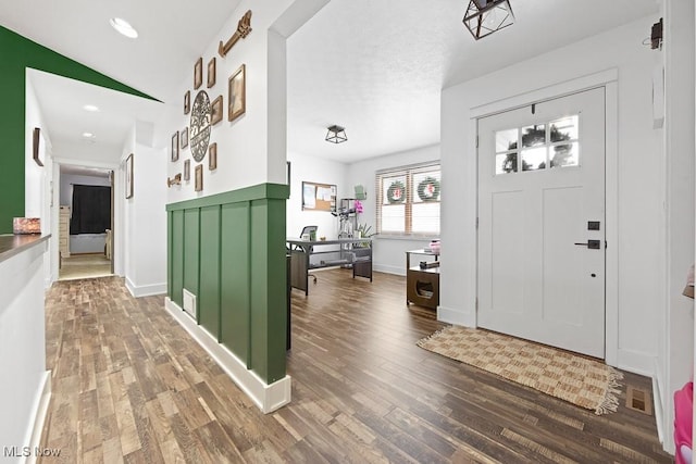 foyer entrance with vaulted ceiling and wood-type flooring