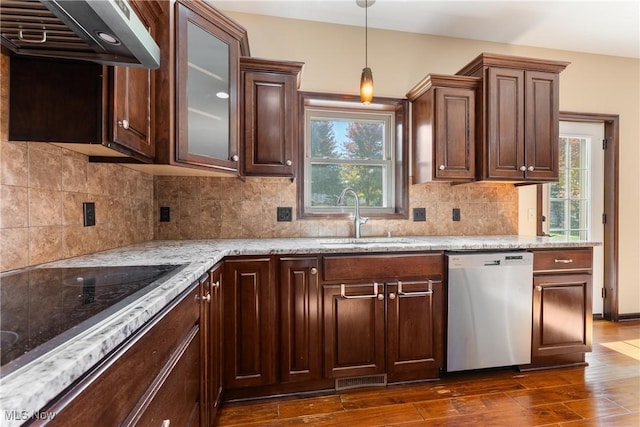 kitchen with exhaust hood, black electric cooktop, dishwasher, light stone counters, and sink