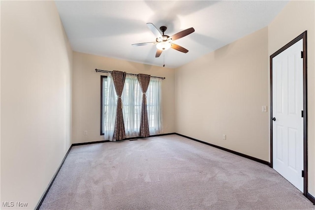 spare room featuring light carpet and ceiling fan