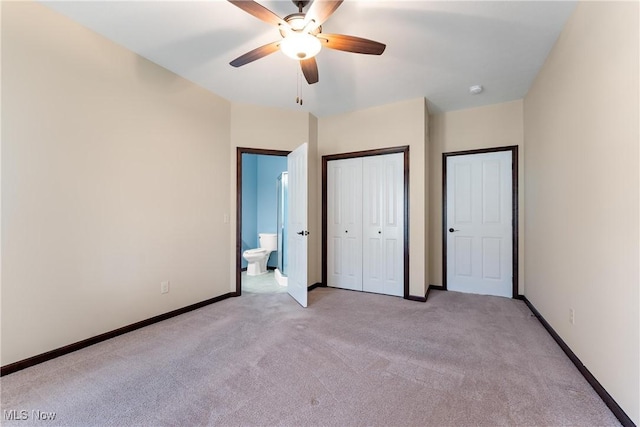 unfurnished bedroom featuring ceiling fan, light colored carpet, and connected bathroom