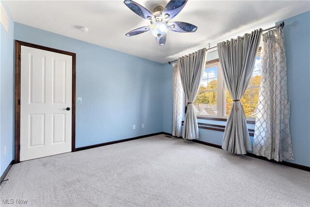 unfurnished room featuring ceiling fan and carpet