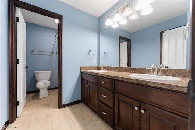 bathroom with toilet, tile patterned flooring, and vanity