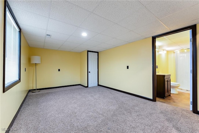 carpeted spare room featuring a paneled ceiling