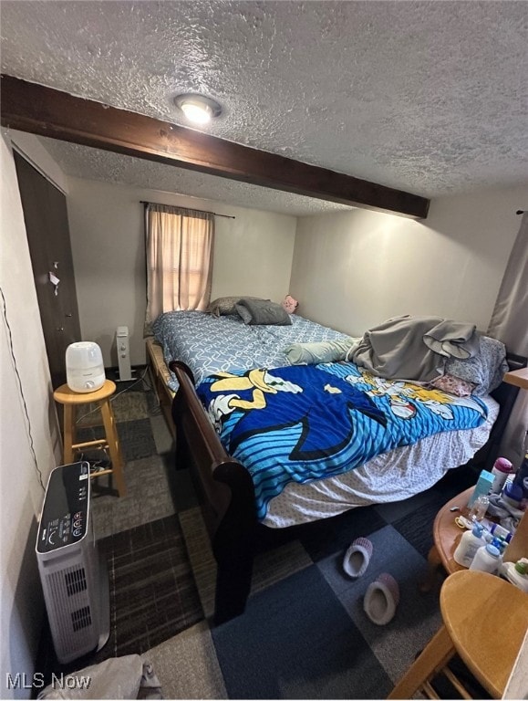 carpeted bedroom with a textured ceiling and beam ceiling