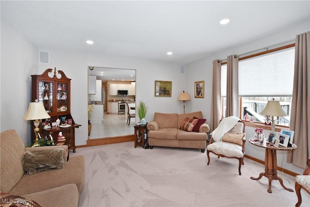 living room featuring light carpet, baseboards, visible vents, and recessed lighting