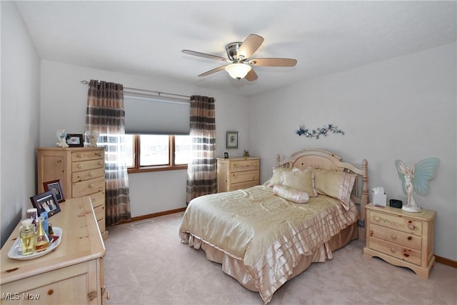 bedroom featuring a ceiling fan, light colored carpet, and baseboards