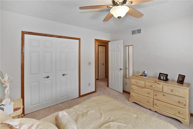 bedroom featuring a closet, visible vents, light carpet, ceiling fan, and baseboards